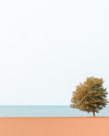 A solitary tree stands on a sandy beach, next to the tranquil blue sea. The scene is calm and peaceful, showcasing the simplicity of nature by the water.の素材