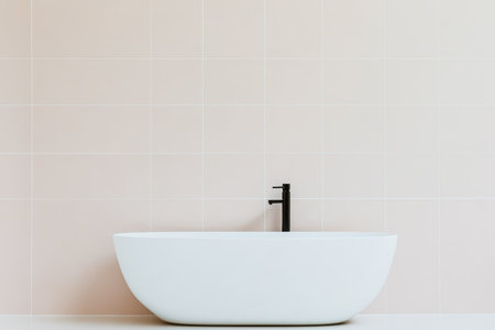 A sleek white bathtub with a black faucet stands out against pale pink tiles. The bathroom features a clean, modern design focused on simplicity and elegance.の素材