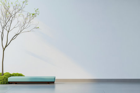 A minimalist space showcases a simple bench with a smooth design, accompanied by a small tree and lush greenery. Soft light enhances the peaceful ambiance of the area.の素材