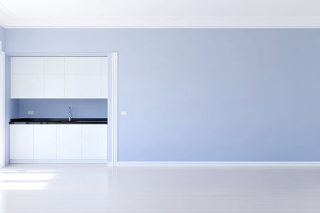 A spacious room features light blue walls and a sleek kitchen area with a black countertop. The bright space is perfect for personalizing with furniture and decor.の素材
