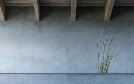 Stylish minimalist scene showcases grass growing from a concrete ledge with a textured gray wall and wooden beams above, creating a serene atmosphere in a contemporary space.の素材