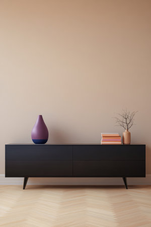A contemporary living room showcases a sleek black media console with two drawers. Decorative vases and a stack of books add color against a warm beige wall, creating a modern and inviting space.の素材
