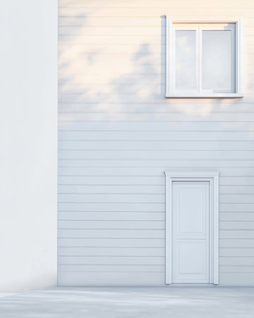 A simple white wall features a small door and a window. The soft light of sunset casts gentle shadows, highlighting the clean lines of the architecture.の素材