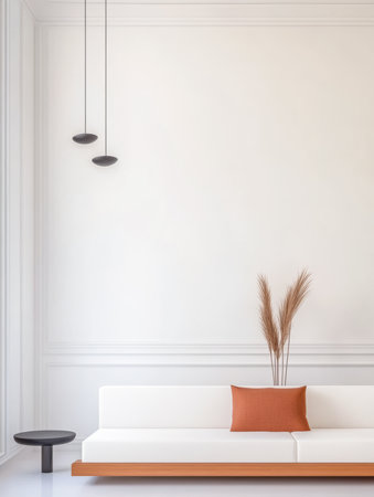 A cozy living area features a white sofa adorned with an orange cushion. Decorative plants add a touch of nature against light-colored walls. Modern lighting complements the simplicity.の素材