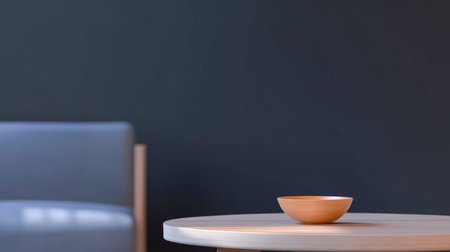 A simple and modern living area showcases a light wooden table with a small bowl placed on it. A sleek gray sofa sits nearby, all against a dark wall.の素材