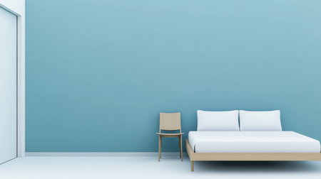 A simple bedroom features a wooden bed with white bedding next to a light wooden chair. The blue wall adds a calming touch, and the space feels open and airy.の素材