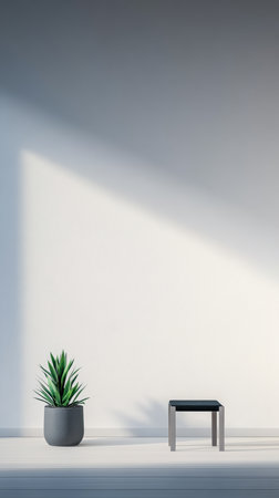 A minimalistic indoor space showcases a small black table next to a vibrant green plant in a gray pot. Soft light illuminates the scene, creating a calm atmosphere.の素材