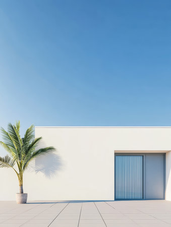 A sleek, minimalist building stands against a bright blue sky. A palm tree in a pot adds a touch of greenery to the modern outdoor space, enhancing the tranquil atmosphere.の素材