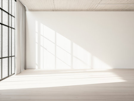 Sunlight streams through large windows, illuminating an empty, spacious room with white walls and wooden floors. Soft shadows create a serene atmosphere in midday light.の素材