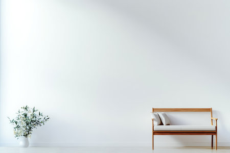 In a bright and spacious room, a sleek wooden bench sits against a plain wall. A simple vase with greenery adds a touch of nature to the clean, minimalist decor.の素材