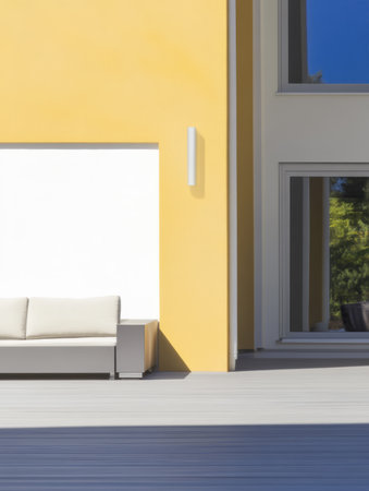 A bright yellow wall highlights a modern outdoor furniture piece next to large reflective windows. The setting is serene and designed for relaxation during the day.の素材