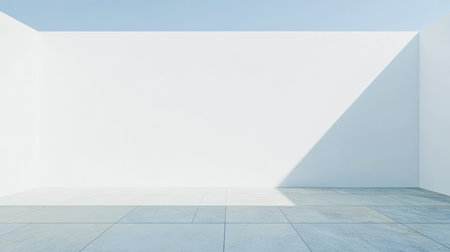 A large, airy space features white walls and a smooth floor. Bright sunlight casts shadows, creating a serene and calm atmosphere in the room.の素材