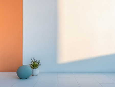 A stylish room showcases an orange accent wall and a light blue wall. Natural light streams in, illuminating a green plant in a white vase and a large round decorative object.の素材