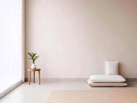 Bright and airy indoor space featuring soft cushions on a light floor, a small round table holding a plant, and large windows letting in natural light for a calming effect.の素材