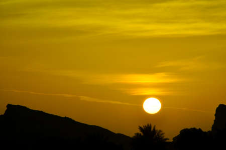 Sunset in Eastern Province, Abu Dhabi. A colourful sky above the peaks of the Hajar Mountains, near Al Ain, UAE, part of the Hajar rangeの写真素材
