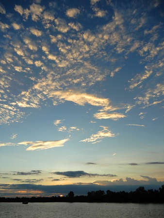 Cloudy skies.  Fluffy white clouds against this blue sky over the river Mekong in Vietnamの写真素材