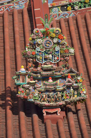 Roof decor. Colourful carvings adorn the roof of this temple in the centre of Georgetown, Malaysiaの写真素材