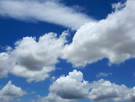 Fluffy white clouds against this blue sky over the river Mekong in Cambodiaの写真素材