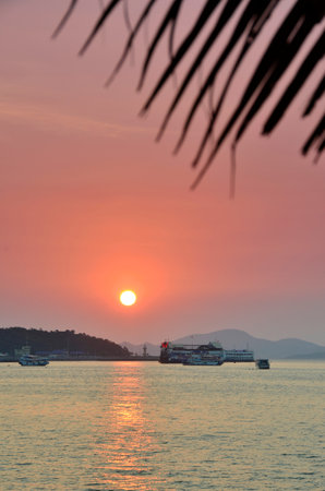 The sun sinking into the Gulf of Thailand pictured here from Pattaya Beach, Thailandの写真素材