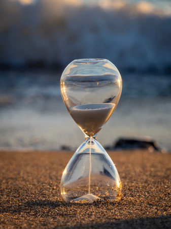 Hourglass on the beach. Concept of time passing. Selective focus.の写真素材