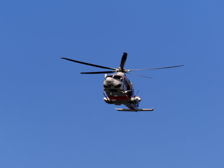 Helicopter in flight against the blue sky on a sunny day
