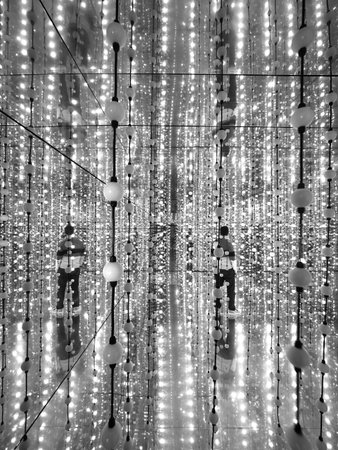 Black and white photo of a lot of light bulbs hanging