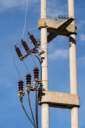 Electricity post with insulators against the blue sky