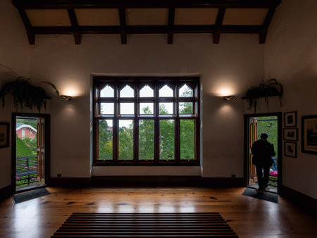 A man standing in front of a large window.