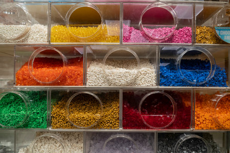 Colorful plastic granules in plastic box for sale in supermarket.