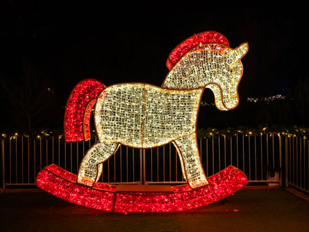 Christmas decoration in the form of a rocking horse on the street at nightの写真素材