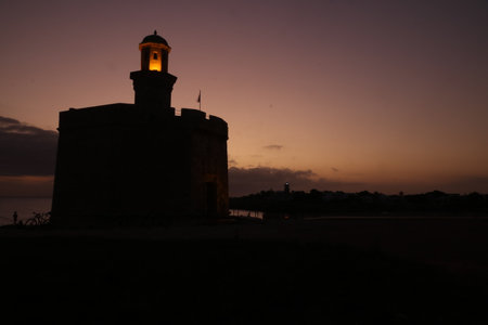 Silhouette of a lighthouse at sunset in Ibiza, Spainの写真素材