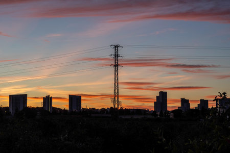 Silhouette of high-voltage power line at sunset.