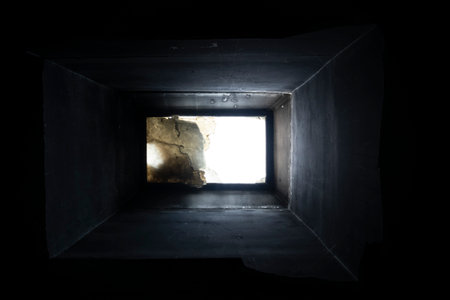 Light from the hole in the wall of the building. Black background.の写真素材