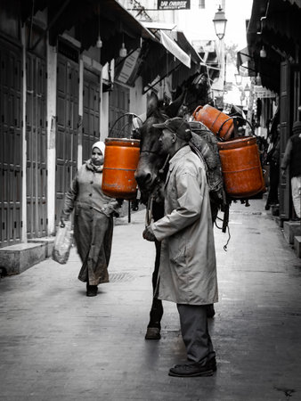 A man with a bucket of water in the old city.の写真素材