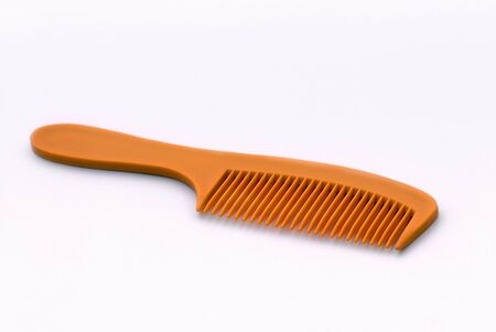Orange coloured plasitc comb for combing hairの写真素材