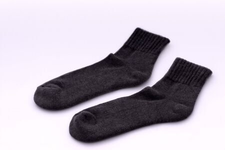 A pair of dark grey socks on white backgroundの写真素材