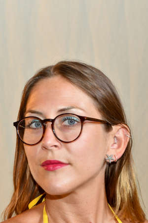 Pretty Young woman with blue eyes and blond hair wearing brown glasses