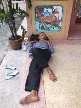 BANGKOK, THAILAND - MAY 16: Thai old man sleeping outside a Chinese temple May 16, 2005 in Bangkok. のeditorial素材