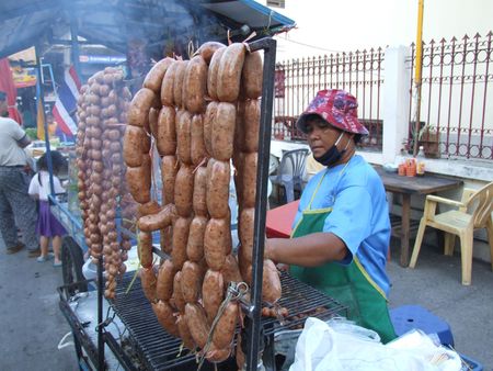 BANGKOK, THAILAND - JANUARY 6: Thai woman cooking and selling sausages on the street January 6, 2005 in Bangkok. のeditorial素材