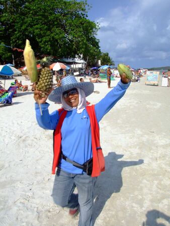 KOH SAMUI, THAILAND - MARCH 8: Thai woman sells fruit to tourists on Haad Chewang beach on March 8, 2007 in Koh Samui. のeditorial素材