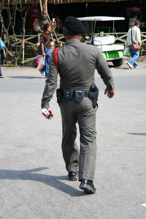 POI PET, THAILAND - 19 JANUARY: Thai police man walks down the road near the Cambodia border crossing on January 19, 2010 in Poi Pet, Thailand. のeditorial素材