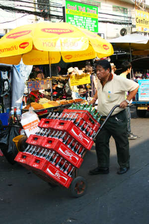 BANGKOK - JANUARY 19: Thai man delivers coke in Khaosarn road on January 19, 2011 in Bangkok, Thailand. のeditorial素材
