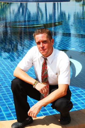 Man outside a swimming pool in Thailand の写真素材
