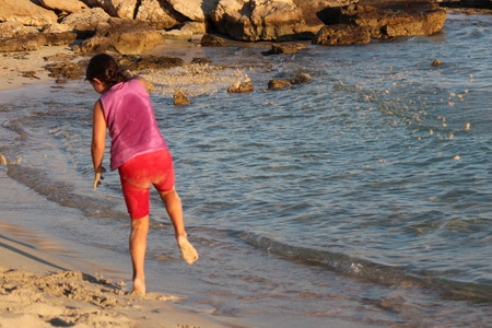 Girl Throwing Sand on Beach, Cyprus.の写真素材