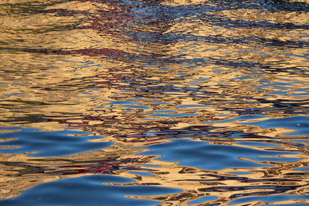 Gold and Blue Reflections on Water at Sunset.の写真素材