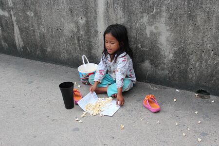 Editorial: Young Girl Begging on Concrete Walkway Over Motorway Interchange, Rangsit, Pathumthani, North Bangkok, 19th October 2013.のeditorial素材