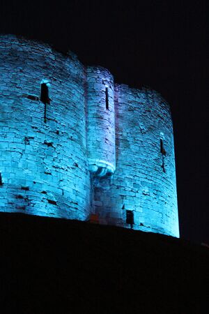 Blue Floodlit Norman Stone Tower.