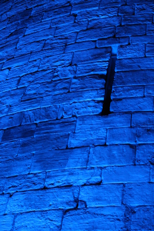 Blue Floodlit Medieval Stone Wall.の写真素材