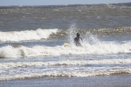 Surfers Brave the Waves on A Cold, Grey, Winter's Day in April.