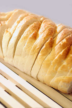 A close up cropped shot of a white sliced loaf of bread on wooden surfaceの写真素材